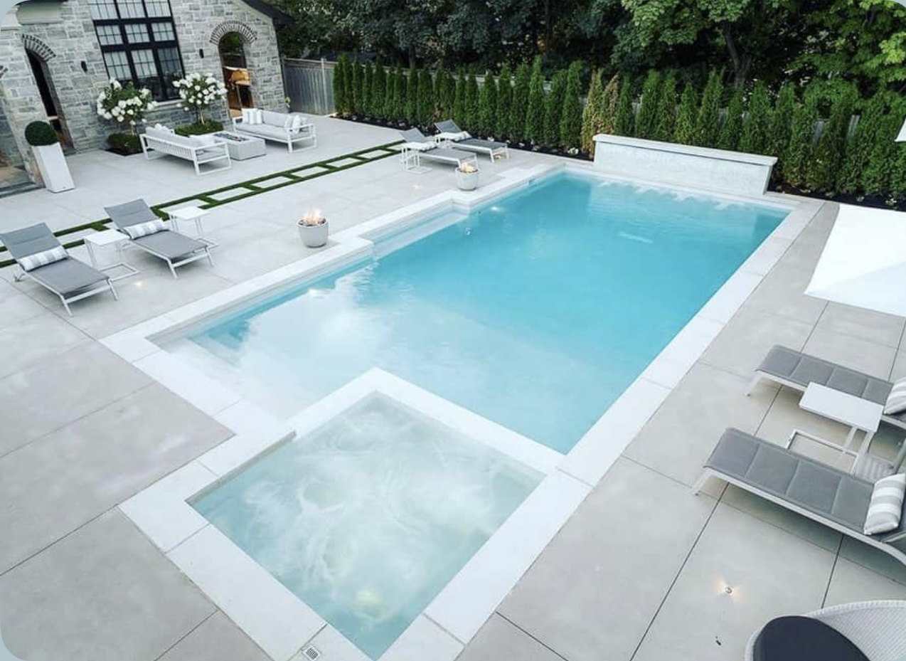 Large geometric swimming pool with separate spa, sun shelf, water wall and formal landscaping
