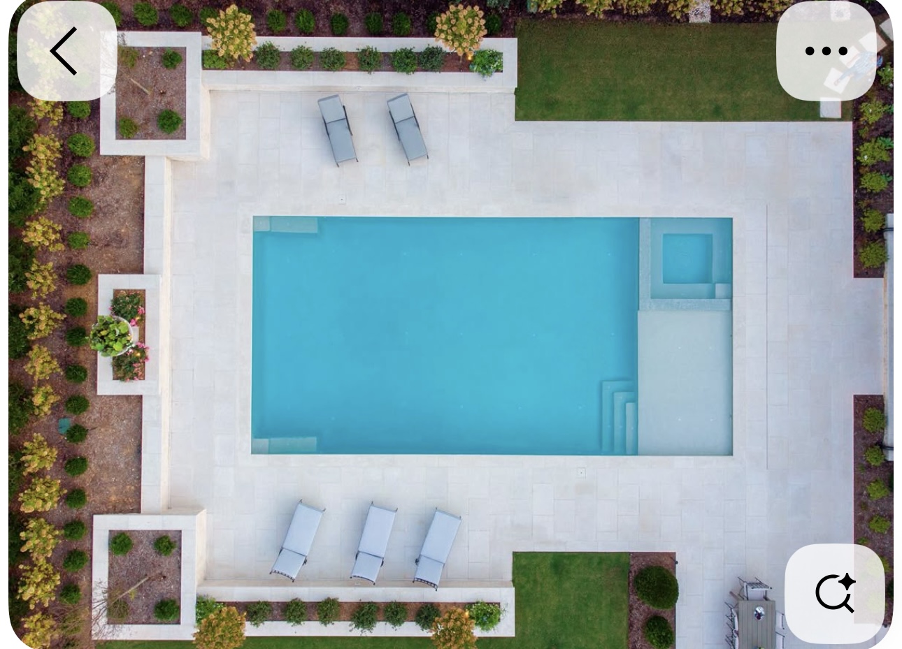 Aerial view of a rectangular pool with integrated spa, steps and surrounding landscape